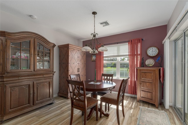 dining area featuring light hardwood / wood-style floors and an inviting chandelier