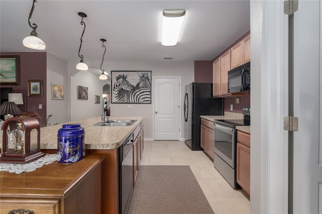 kitchen with black appliances, sink, a textured ceiling, pendant lighting, and a kitchen island with sink