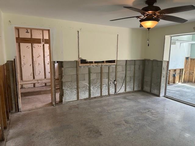 interior space with ceiling fan and concrete flooring