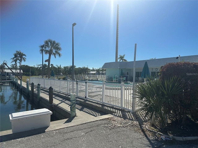 view of dock featuring a water view and a community pool