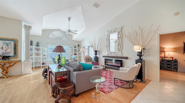 living room featuring high vaulted ceiling, a textured ceiling, light tile patterned floors, and ceiling fan