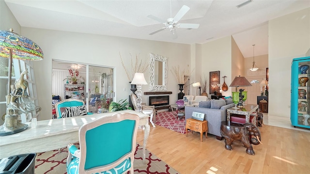 living room with hardwood / wood-style flooring, high vaulted ceiling, and ceiling fan