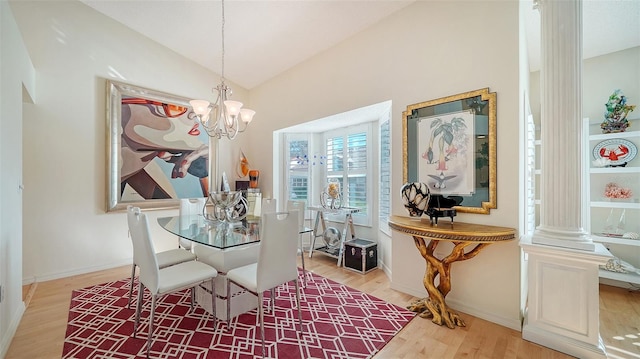 dining room featuring an inviting chandelier, vaulted ceiling, ornate columns, and light hardwood / wood-style floors