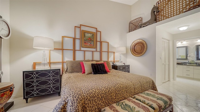 bedroom with connected bathroom, a closet, and light tile patterned floors