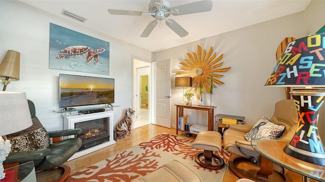 sitting room with ceiling fan and hardwood / wood-style flooring