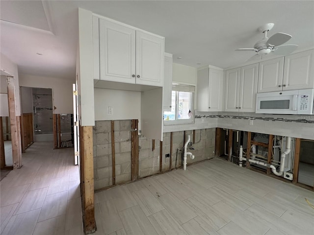 kitchen featuring white cabinets and ceiling fan