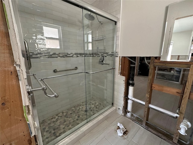 bathroom featuring a shower with door