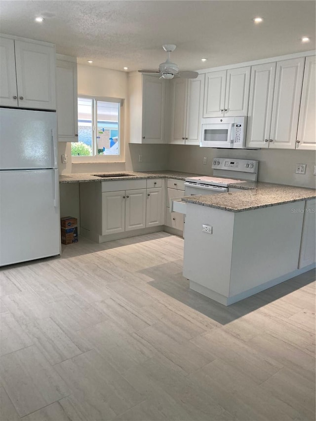 kitchen featuring light hardwood / wood-style floors, ceiling fan, a textured ceiling, white appliances, and white cabinets