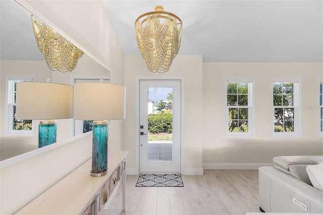 entryway with light hardwood / wood-style floors and a chandelier