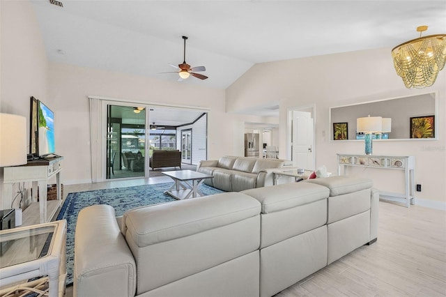 living room featuring light hardwood / wood-style floors, high vaulted ceiling, and ceiling fan with notable chandelier