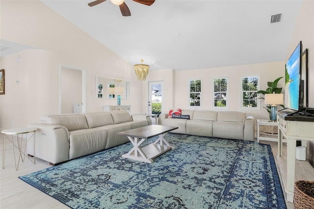 living room featuring hardwood / wood-style flooring, high vaulted ceiling, and ceiling fan with notable chandelier