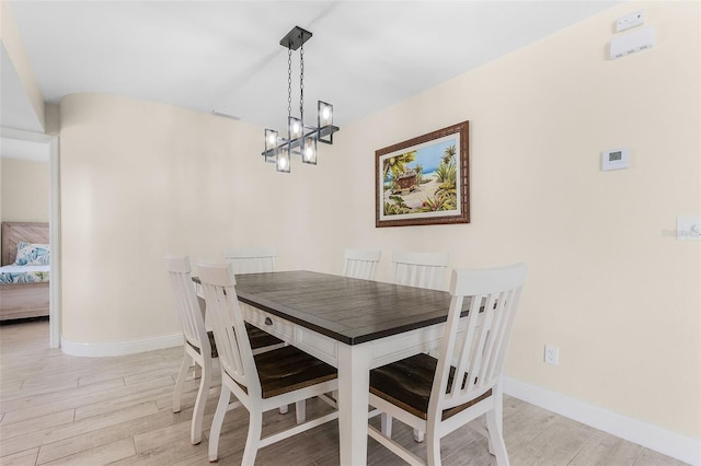 dining room with a chandelier and light wood-type flooring