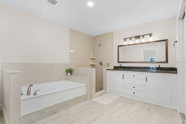 bathroom with vanity, hardwood / wood-style floors, and shower with separate bathtub