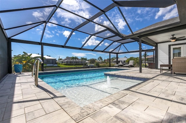 view of swimming pool featuring pool water feature, ceiling fan, a patio, and a lanai