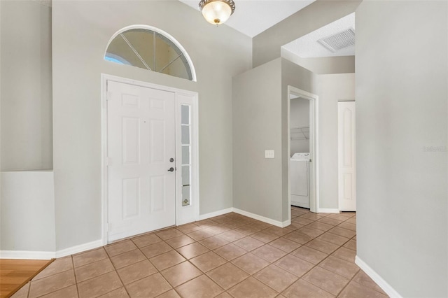 foyer with washer / clothes dryer and light tile patterned floors