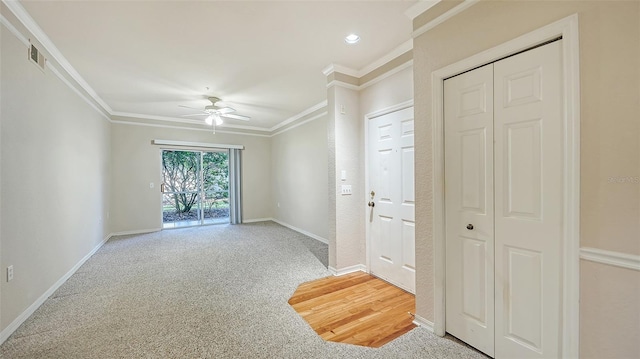 carpeted spare room featuring ceiling fan and ornamental molding