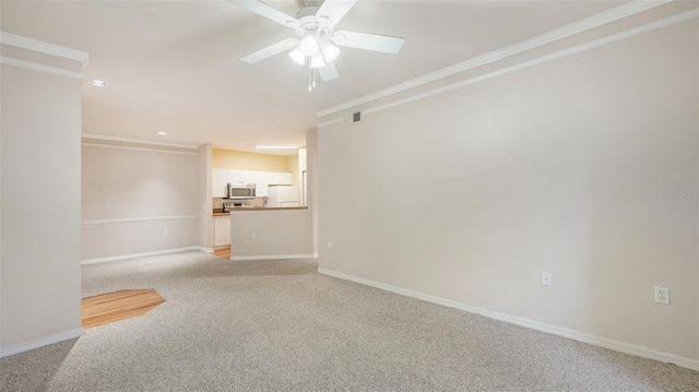 spare room with crown molding, light colored carpet, and ceiling fan