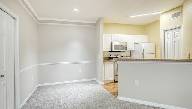 kitchen featuring white cabinetry, stainless steel appliances, decorative backsplash, and light colored carpet