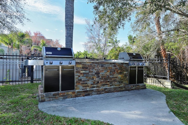 view of patio / terrace featuring an outdoor kitchen and a grill