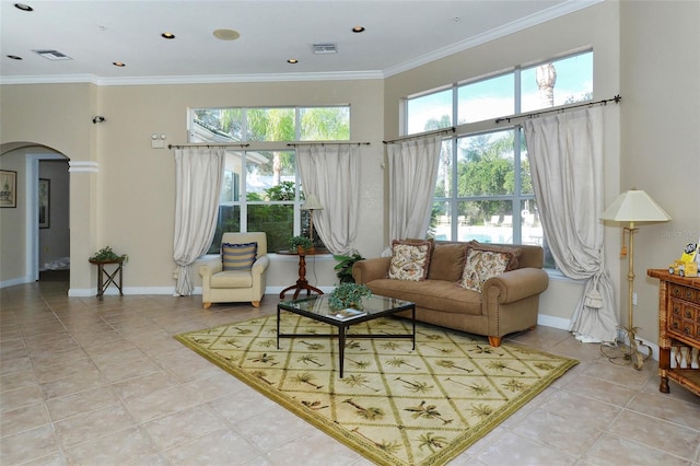 living room with crown molding, a wealth of natural light, and light tile patterned floors