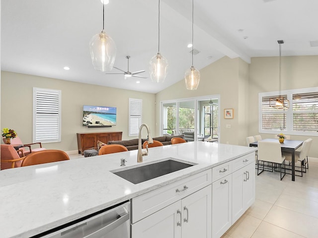 kitchen with light stone countertops, stainless steel dishwasher, sink, white cabinets, and vaulted ceiling with beams