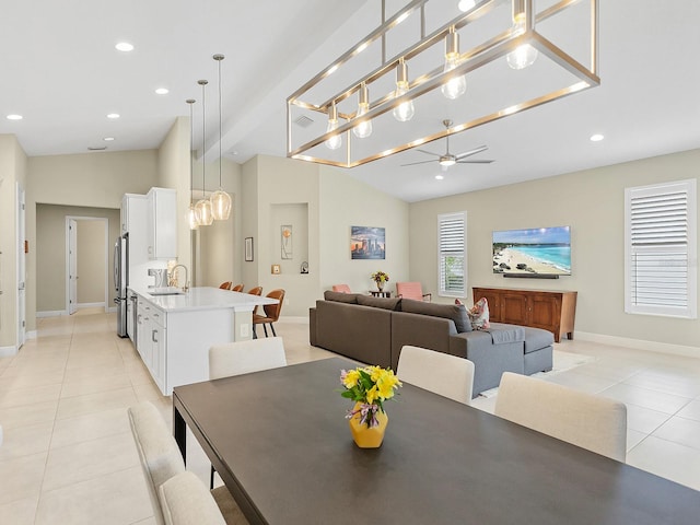 tiled dining room with ceiling fan, sink, and lofted ceiling