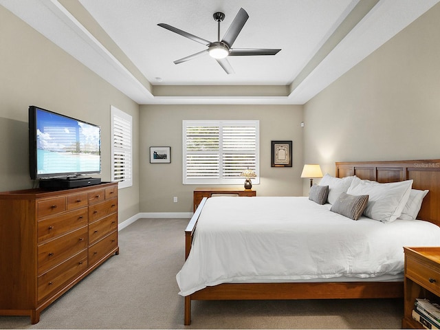 bedroom featuring a tray ceiling, ceiling fan, and light carpet