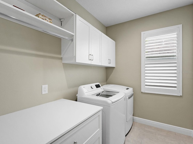 washroom featuring cabinets and washing machine and clothes dryer