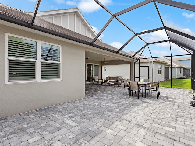 view of patio / terrace featuring outdoor lounge area, ceiling fan, and glass enclosure