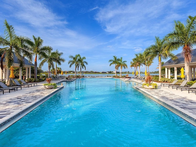 view of pool with a patio and a water view