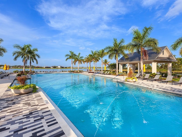 view of pool with a water view and a patio