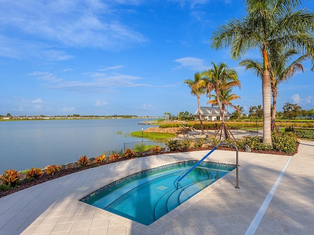 view of swimming pool featuring a water view and an in ground hot tub