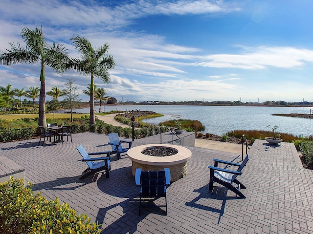 view of patio with a water view and a fire pit