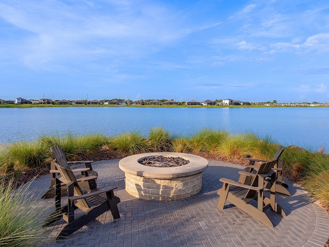 view of patio with a water view and an outdoor fire pit