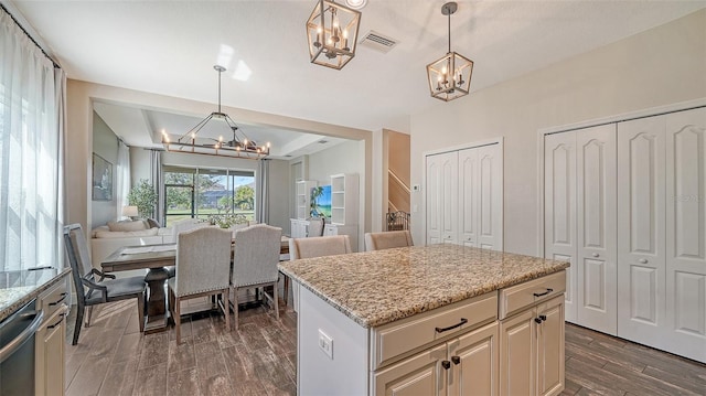 kitchen with stainless steel dishwasher, a kitchen island, decorative light fixtures, and dark hardwood / wood-style floors