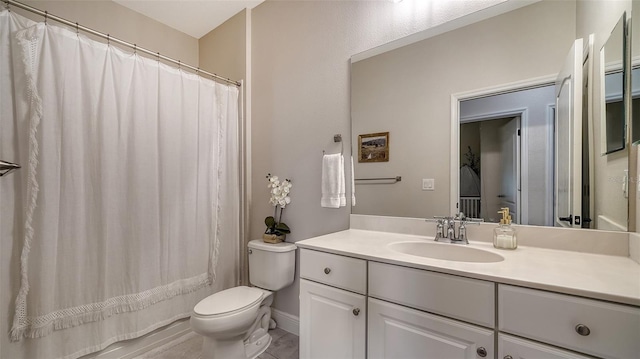 bathroom featuring vanity, curtained shower, and toilet