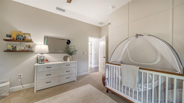 bedroom with light carpet and a crib