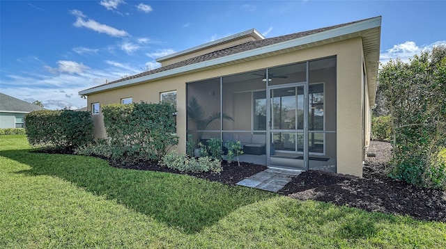 rear view of house featuring a yard and a sunroom