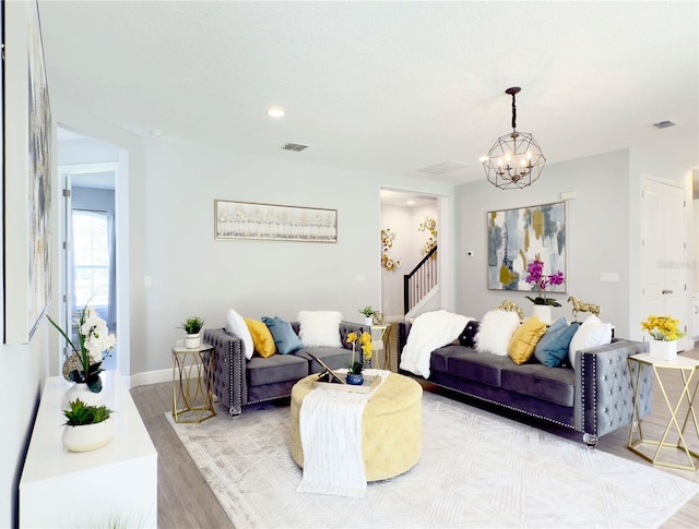 living room featuring a chandelier and light wood-type flooring