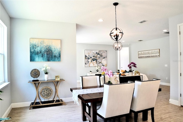 dining area featuring a chandelier and light hardwood / wood-style floors