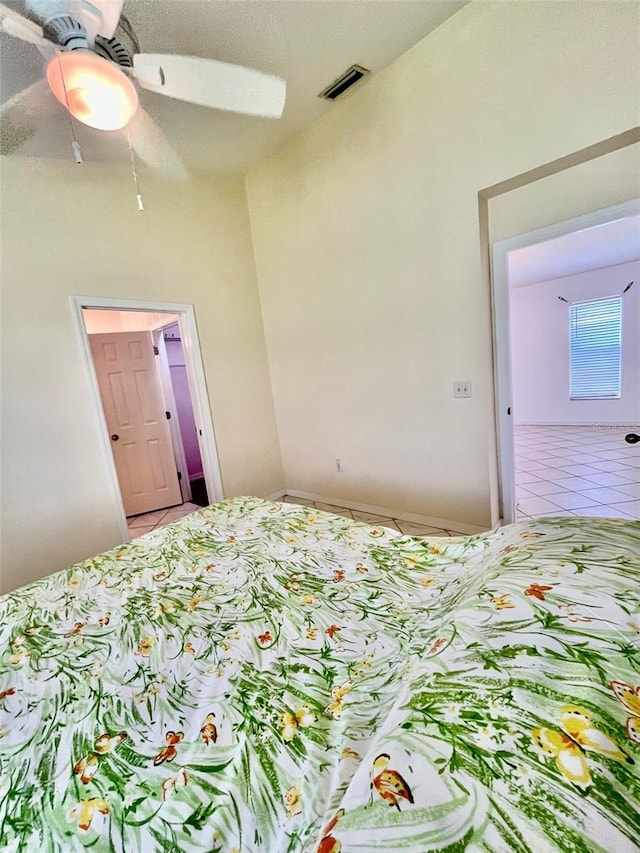 bedroom featuring a textured ceiling, tile patterned flooring, and ceiling fan