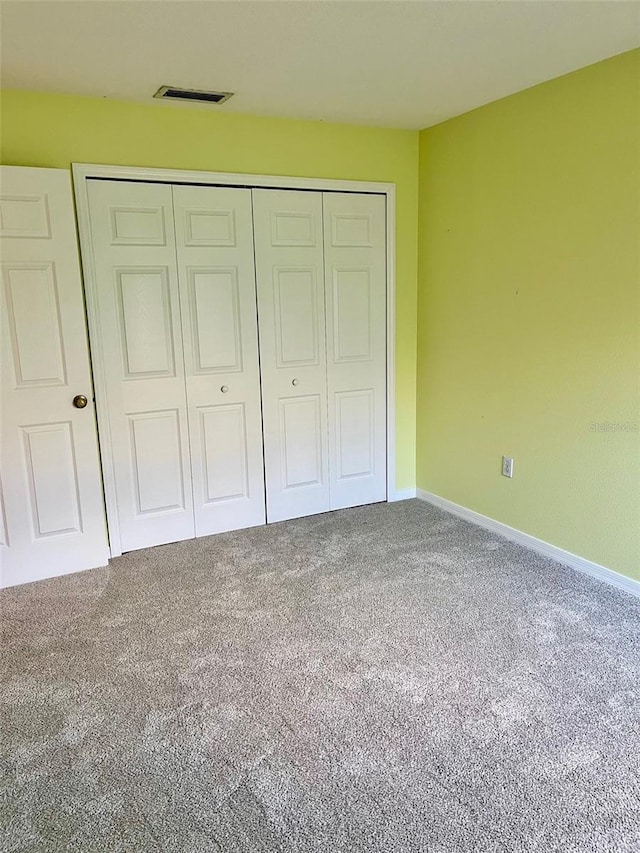 unfurnished bedroom with a closet and carpet