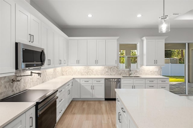 kitchen featuring white cabinetry, stainless steel appliances, and a wealth of natural light