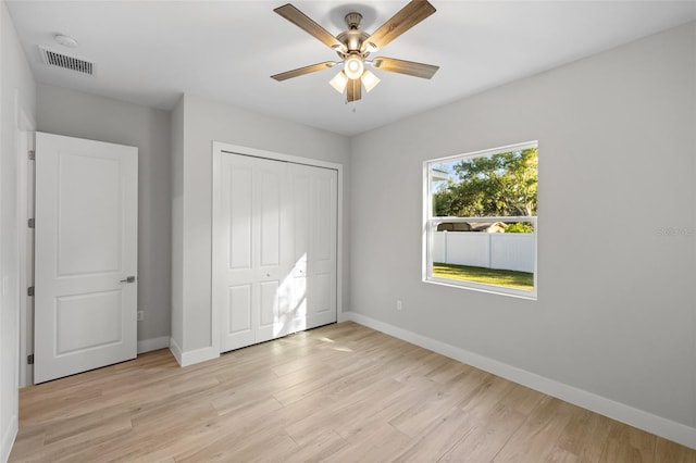 unfurnished bedroom with a closet, light wood-type flooring, and ceiling fan