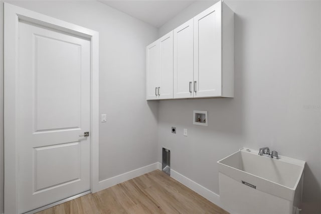 clothes washing area with cabinets, washer hookup, light wood-type flooring, hookup for an electric dryer, and sink