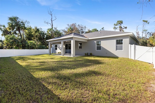 rear view of property featuring a patio area and a lawn