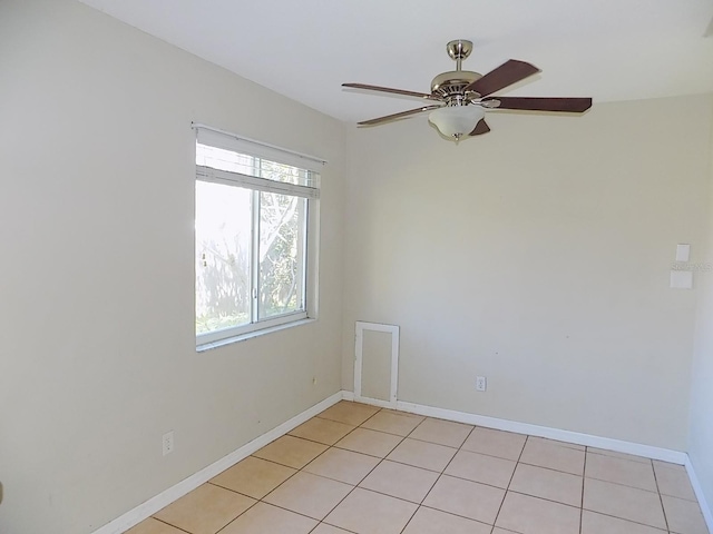 tiled spare room with ceiling fan