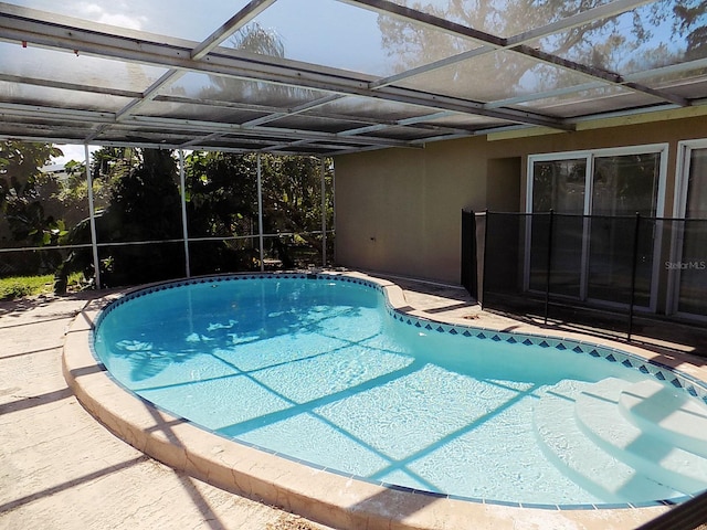 view of swimming pool featuring a lanai