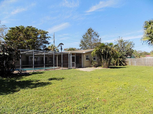 view of yard with a fenced in pool and glass enclosure