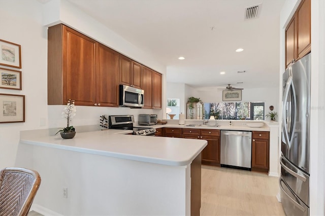 kitchen featuring appliances with stainless steel finishes, ceiling fan, sink, and kitchen peninsula